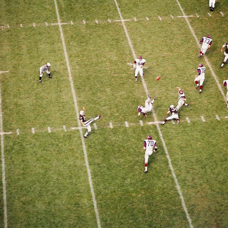 AKG2154470 1970s ACTION SPORTS COLLEGE FOOTBALL GAME PLAYER KICKING FOOTBALL. © ClassicStock / akg-images / H. Armstrong Roberts