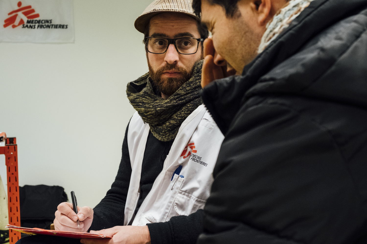 Un psychologue de MSF écoute un migrant afghan lors d'une consultation au Hub humanitaire de la gare du Nord en janvier 2018. (c) Bruno De Cock/MSF
