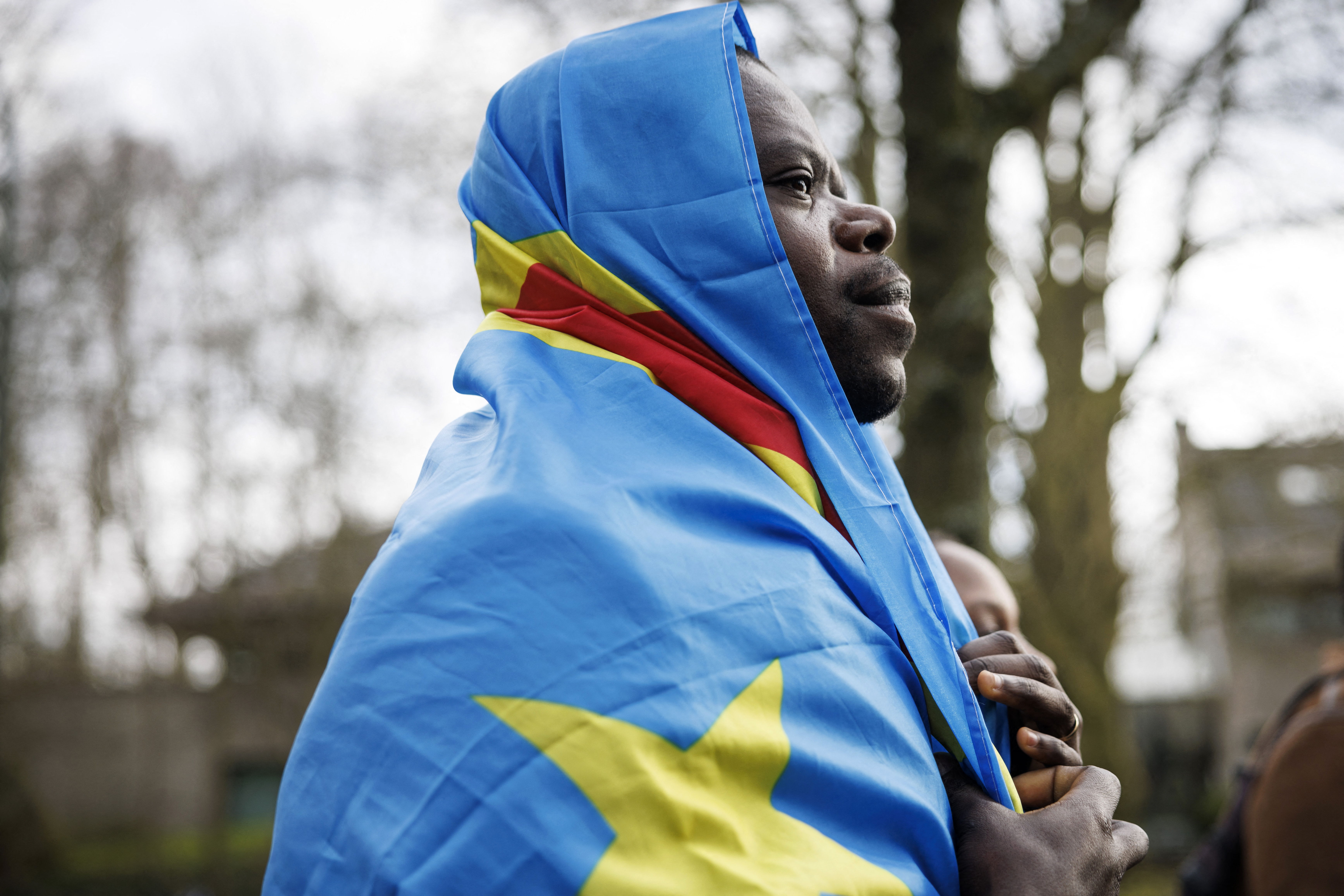 A demonstrator wrapped in the Congolese national flag takes part in a protest in front of the Embassy of Rwanda in Brussels © PHOTO SIMON WOHLFARHT / AFP