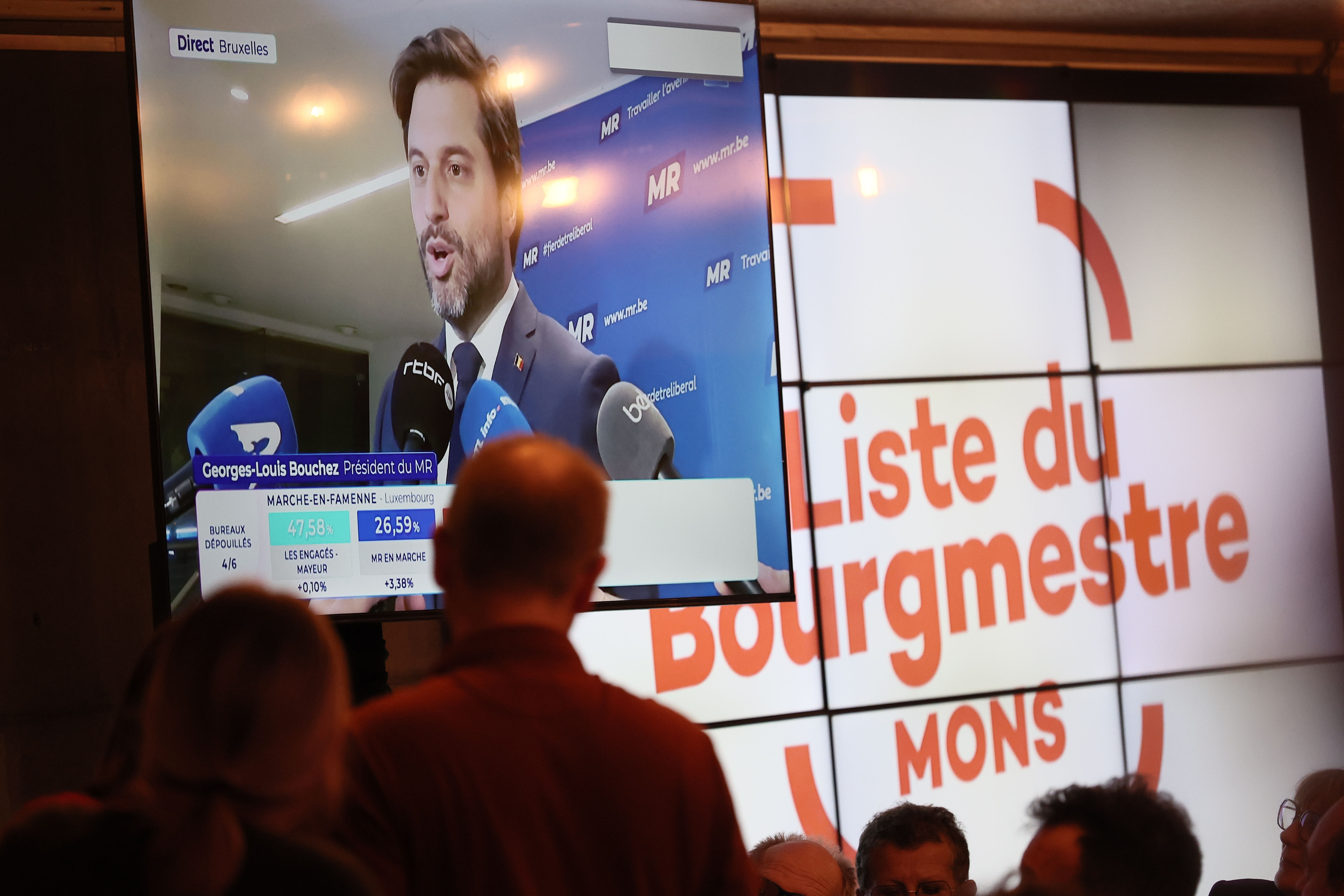 MR-voorzitter Georges-Louis Bouchez te zien op een scherm tijdens een vergadering van de Franstalige socialistische partij PS van Mons, op de avond van de gemeenteraadsverkiezingen op zondag 13 oktober 2024. © Belgaimage - BRUNO FAHY