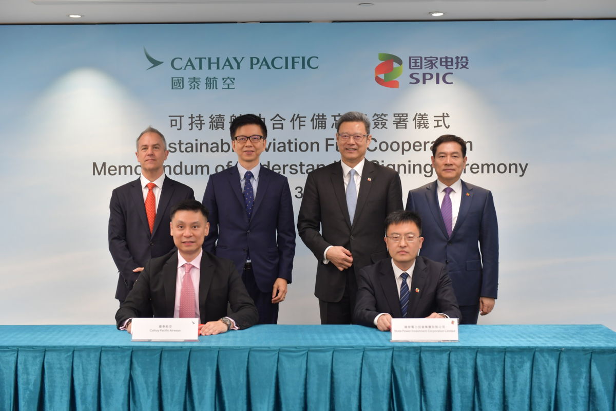 Witnessed by SPIC Chairman Qian Zhimin (standing, second from right) and Vice President Chen Haibin (standing, first from right), Cathay Pacific Group Chief Executive Officer Ronald Lam (standing, second from left), and Chief Operations and Service Delivery Officer-designate Alex McGowan (standing, first from left), the MoU was signed by SPIC International Finance (HK) Co. Ltd. Chairman Yin Guoping (seated, right) and Cathay Pacific General Manager Corporate Affairs Andy Wong (seated, left).