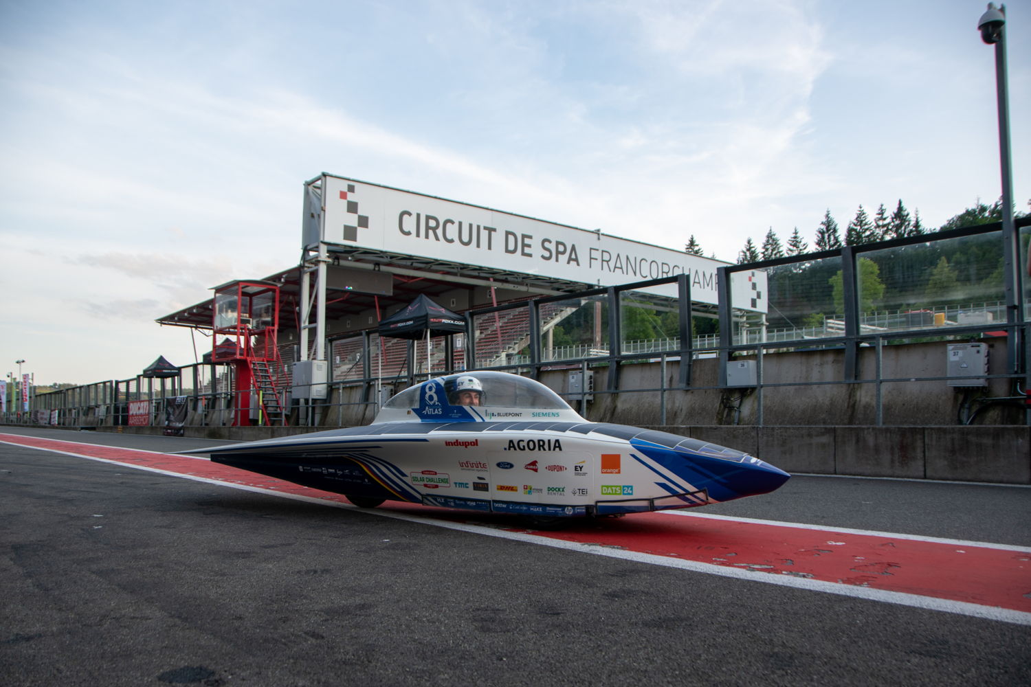 De zonnewagen staat klaar in de pitlane van het circuit.