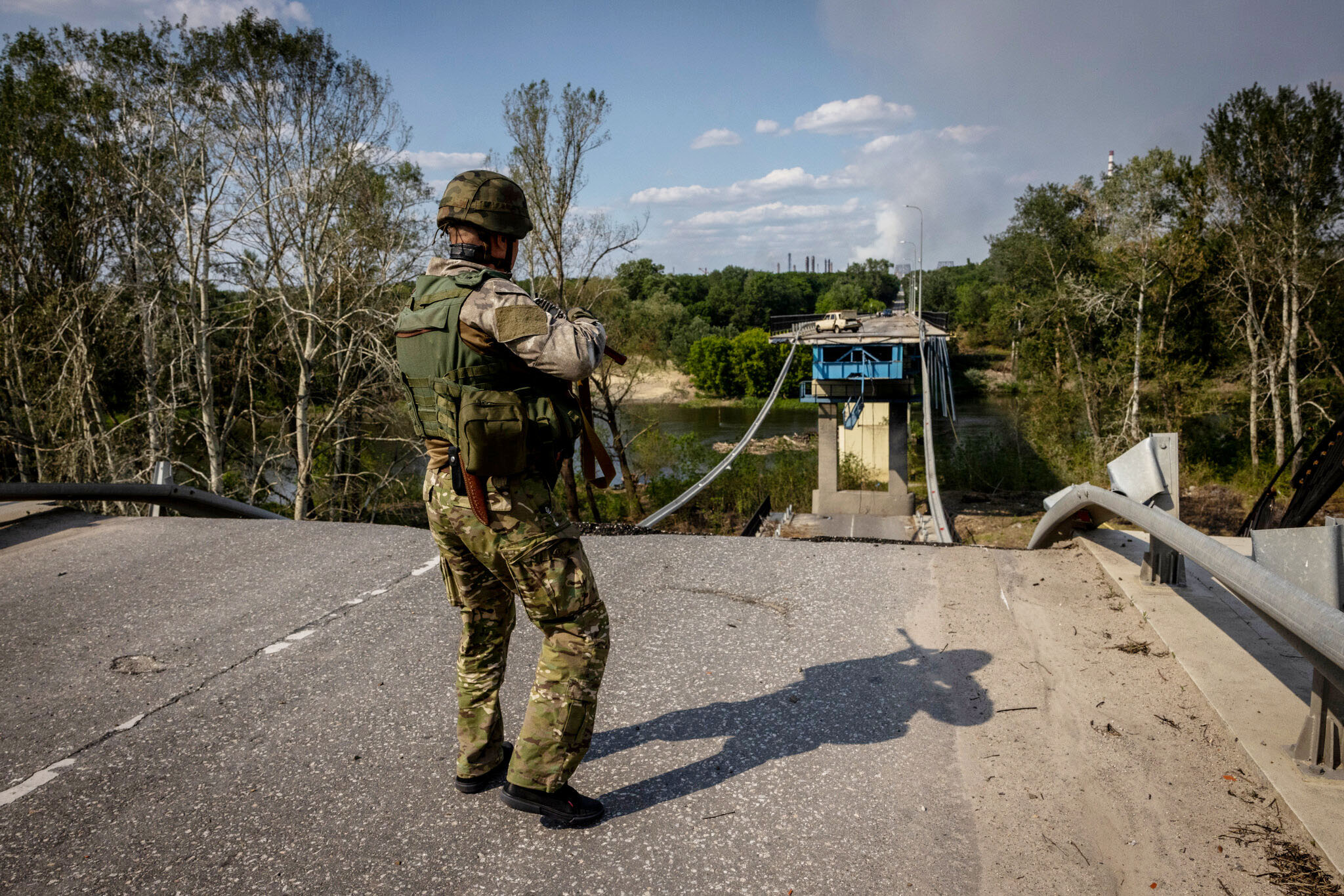 A Ukrainian police officer near a destroyed bridge that once connected the embattled cities of Lysychansk and Sievierodonetsk. Ivor Prickett for The New York Times