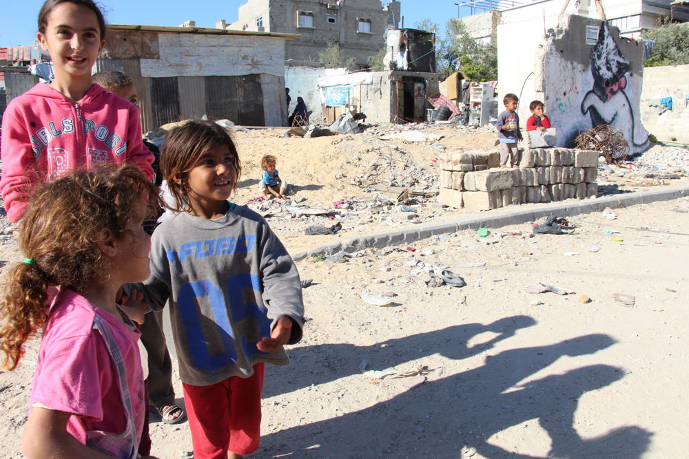 Beit Hanoun in north Gaza strip, severely hit by last war, still many destroyed houses - children of the neighbourhood in front of Banksy mural of the cat, near the UNRWA school which still hosts 53 families who lost their homes during Protective Edge. © Susanne Doettling/MSF Beit Hanoun in north Gaza strip, severely hit by last war, still many destroyed houses - children of the neighbourhood in front of Banksy mural of the cat, near the UNRWA school which still hosts 53 families who lost their homes during Protective Edge. © Susanne Doettling/MSF