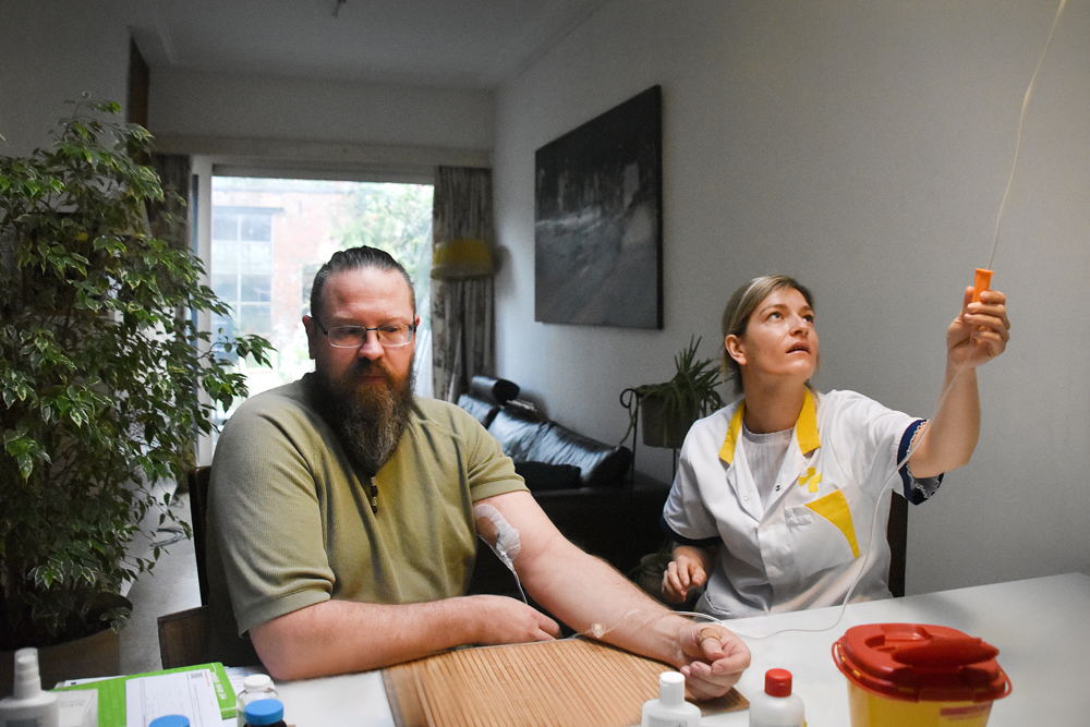 Een patiënt krijgt thuis antibiotica in plaats van in het ziekenhuis. (Foto: Wit-Gele Kruis)