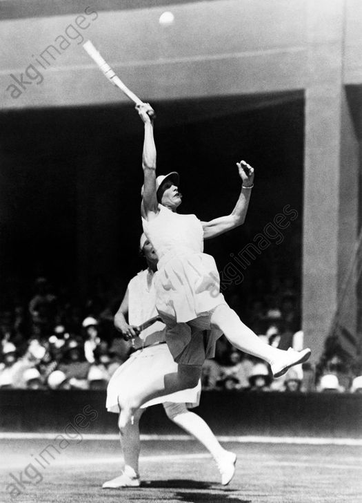 AKG5248265 - Kea Bouman of the Netherlands leaps high to try to return a high ball in the Doubles quarterfinals at Wimbledon. Her partner is British player Evelyn Colyer. 1928