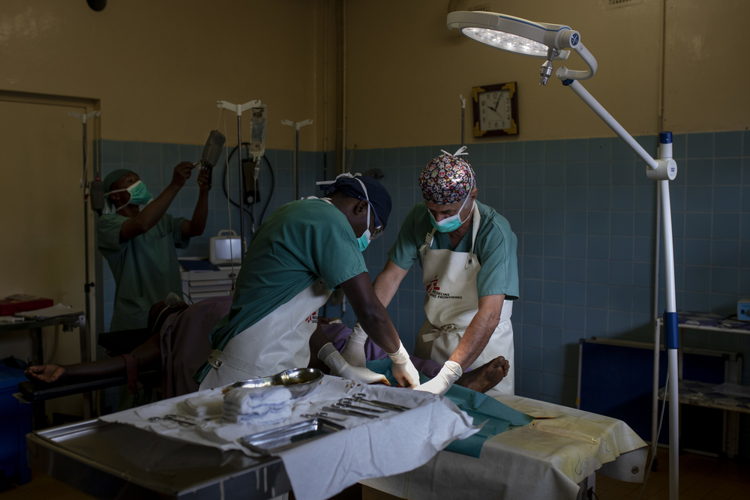Des médecins de l'hôpital général de Masisi nettoient les plaies d'un patient blessé par balle à la jambe après avoir été dépouillé par des hommes armés © Pablo Garrigos/MSF