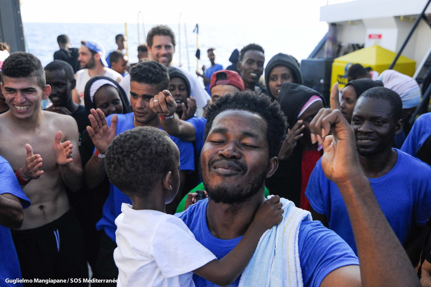 Rescued people on board Aquarius sing on the main deck, August 2018. Copyright: Guglielmo Mangiapane/SOS MEDITERRANEE