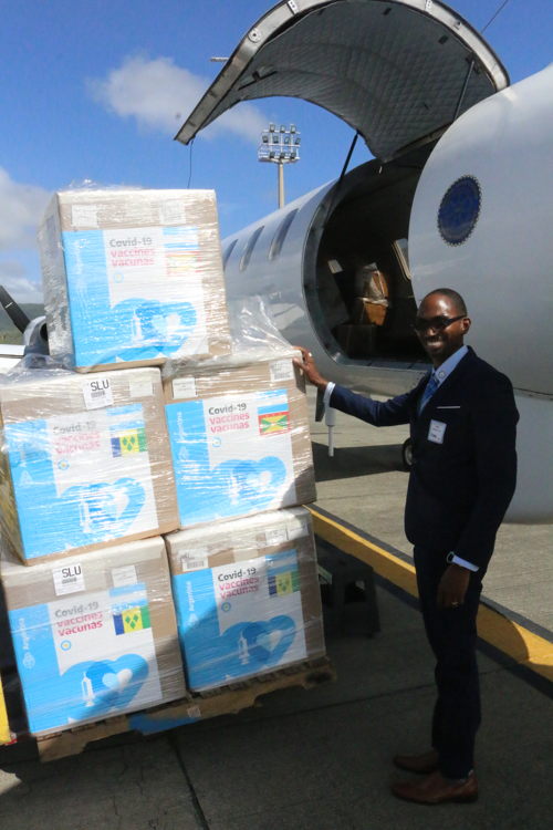 Senior Technical Specialist at the OECS Pharmaceutical Procurement Service Abraham Weekes and the stock of vaccines to be dispatched to Grenada, Saint Vincent and the Grenadines and the Commonwealth of Dominica via a flight of the Regional Security System