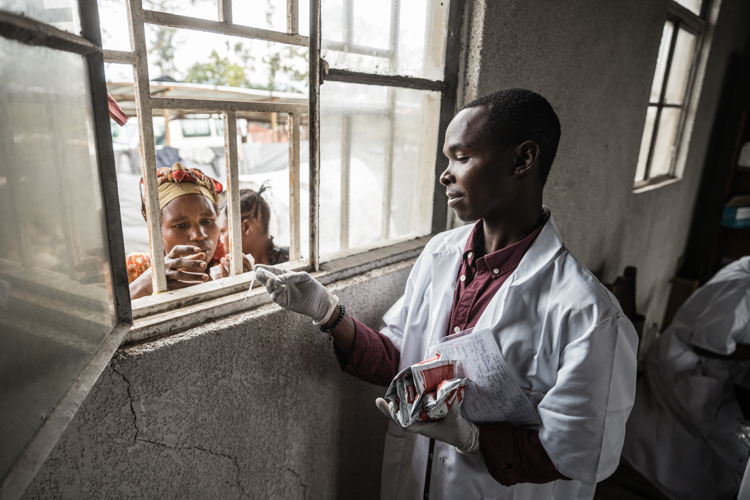 Samuel Mugabo is providing nutritional therapeutic food and medications to Foibe Bonane, a displaced mother whose child is battling malnutrition and measles. Copyright - Michel Lunanga/MSF