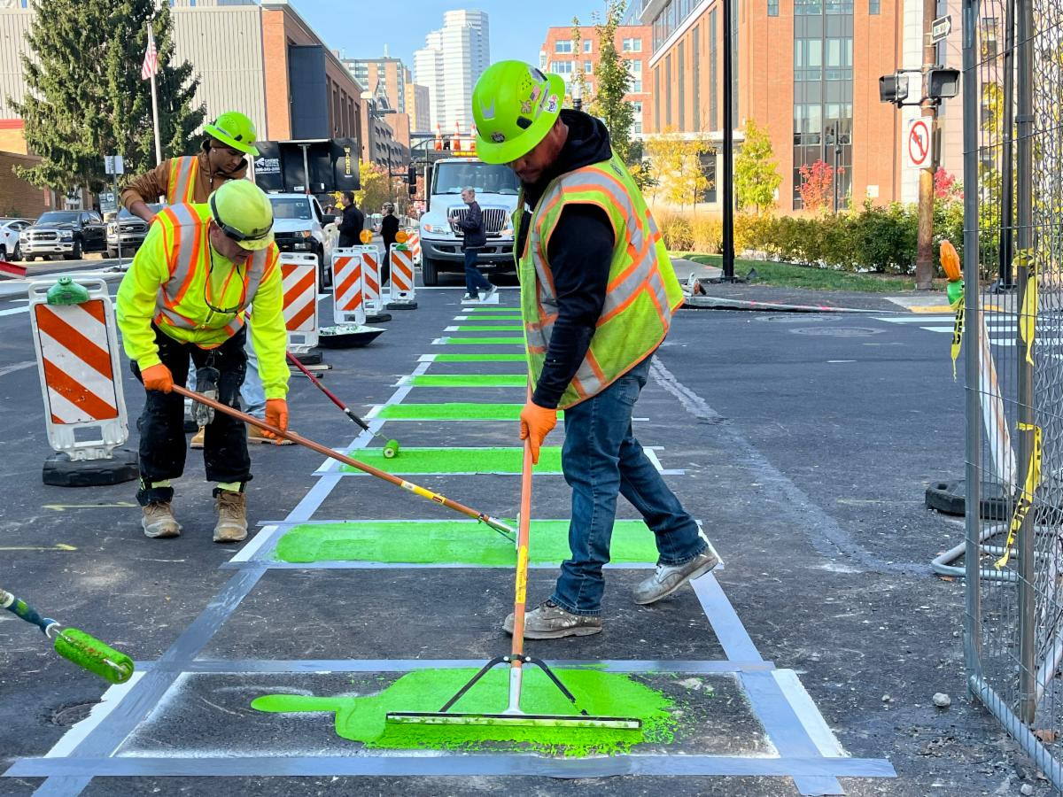 Crews place green paint to signify the bike lane on Forbes Avenue in Uptown Crews place green paint to signify the bike lane on Forbes Avenue in Uptown