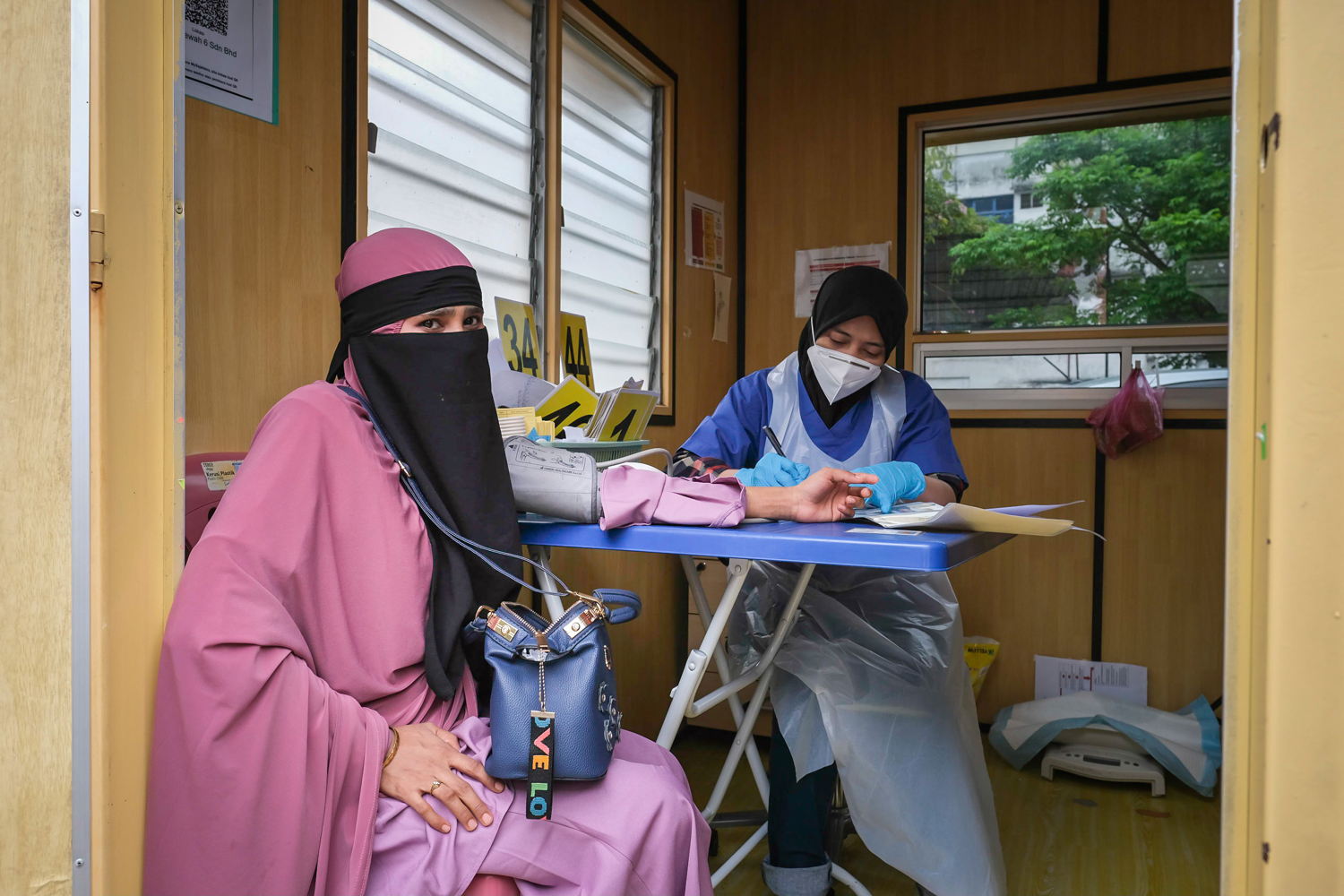 A Rohingya woman who is six months pregnant is examined by triage nurse, Izyan, at the MSF clinic in Butterworth, Penang, as part of her first prenatal medical check-up. Photographer: Kit Chan. Date: 09/05/2022. Location: Malaysia 