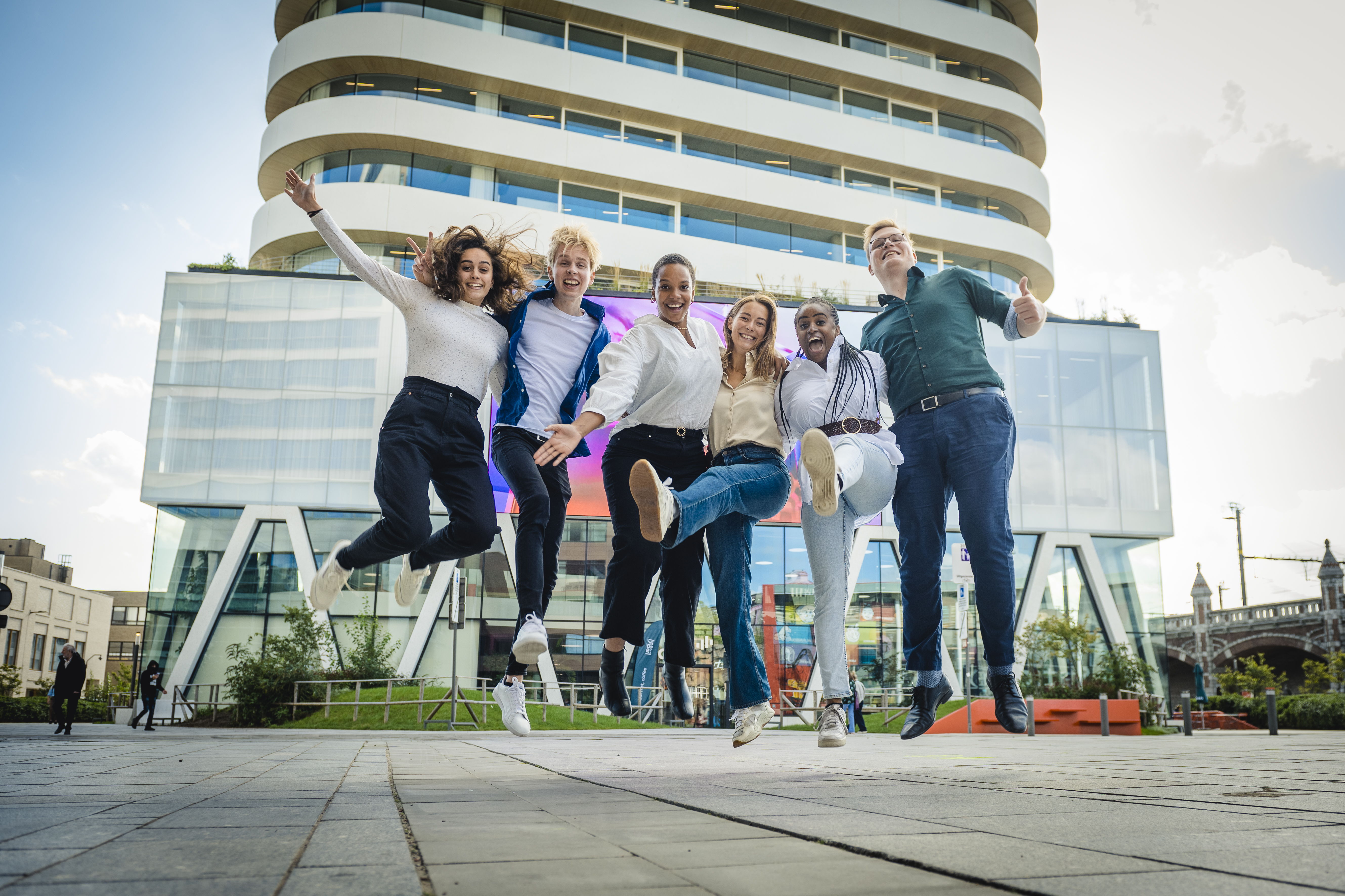 Glenn, Margo, Nikias, Ester, Rachel en Chloë voor het iconische gebouw van DPG Media in Antwerpen.