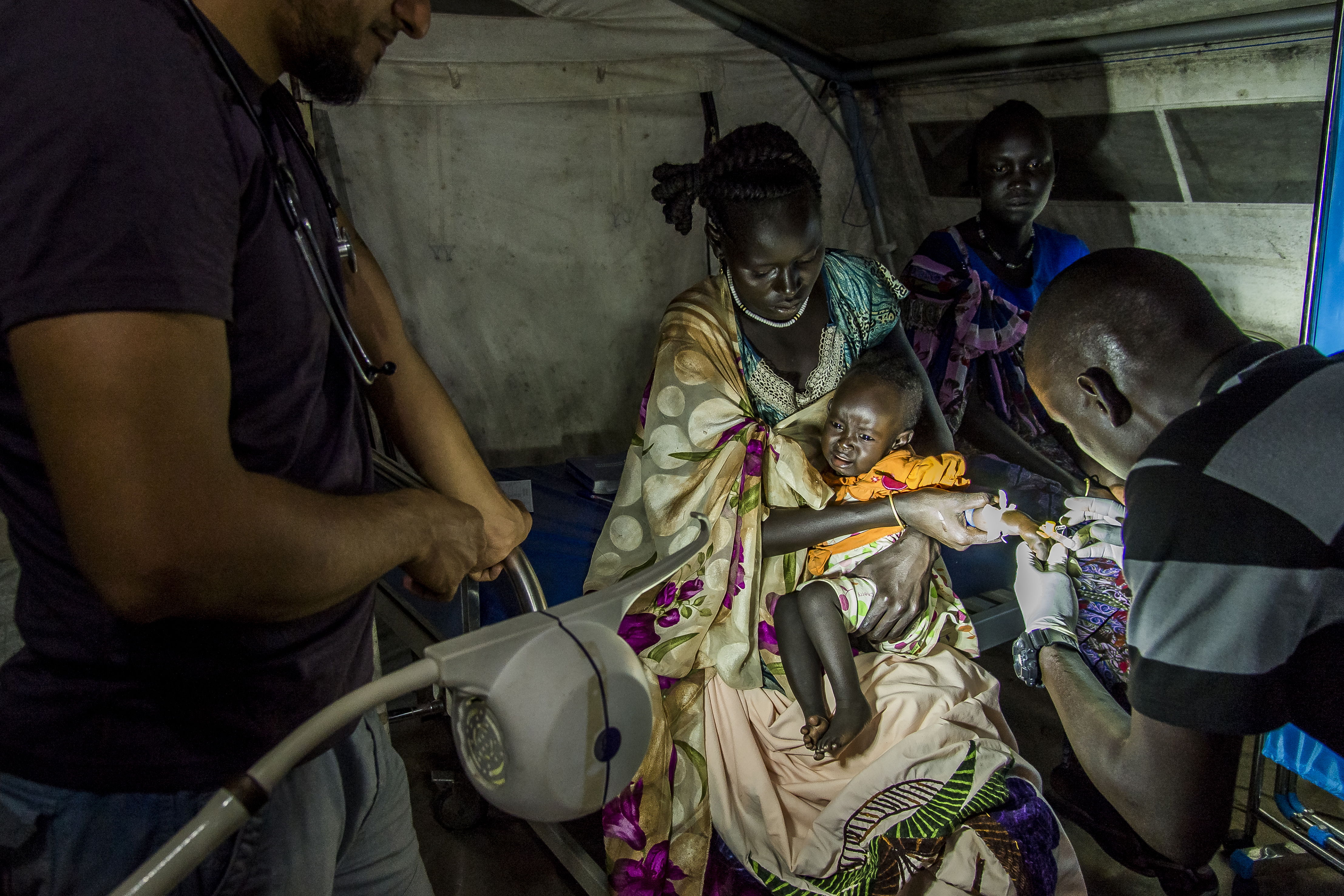 Emergency ward of the MSF's Old Fangak clinic, in South Sudan. Medical worker prepares to treat a young girl with malaria. COPYRIGHT: Frederic NOY