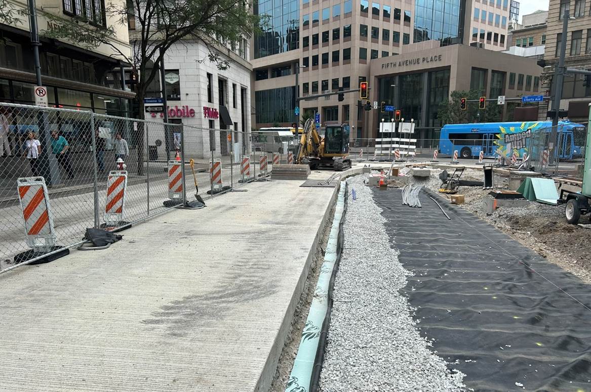 Inside the work zone at Fifth Avenue and Market Street, contractors are preparing for granite curb installation