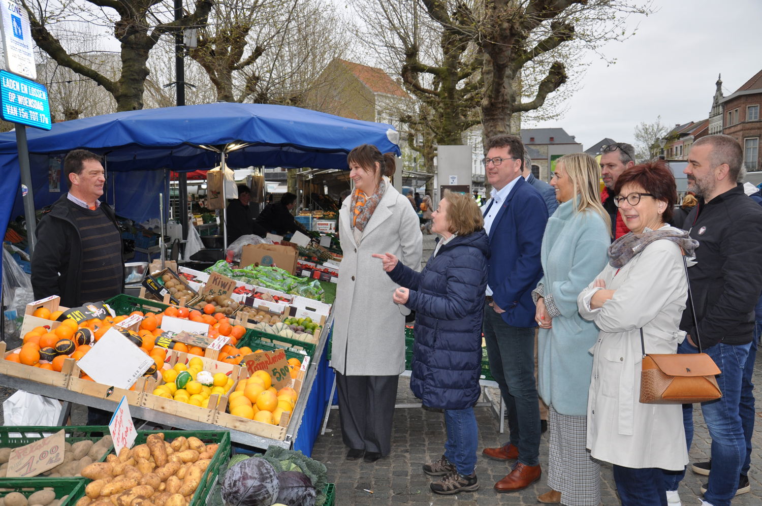 vlnt: marktkramer, gedeputeerde Leentje Grillaert, Marleen Van Hecke, marktleider van de stad Lokeren, burgemeester Filip Anthuenis, schepen Filip Liebaut (achter rug van burgemeester), schepen Claudine De Waele, slager Tony, marktkramer en chef van de markt vanuit de kant van de marktkramers zelf, schepen Marina Van Hoorick, schepen Stefan Walgraeve, daarachter weggestoken de voorzitter van de Vlaamse Federatie voor ambulante handel, Johan De Leeuw