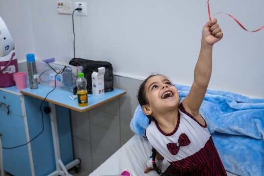 Four-year-old Hala plays with a balloon just one day after surgeons with the MSF limb reconstruction unit at Al-Awda in Gaza hospital operated on her foot.