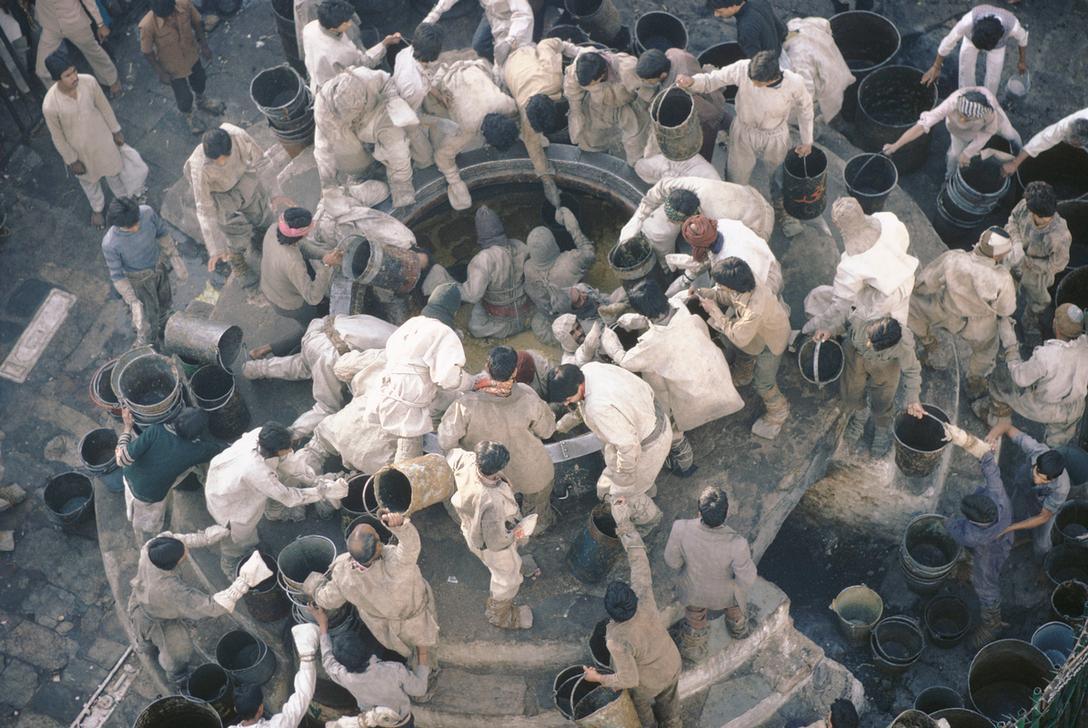 Urs Festival: khichdi (rice with lentils) is cooked in two large caudlrons, donated by the Mughal emperors Akbar and Jahangir (holding 2612 and 1045 litres), and is handed out to the pilgrims. Men in special suits climb down the cauldrons to scoop the khichdi, India, 1987. AKG1523676