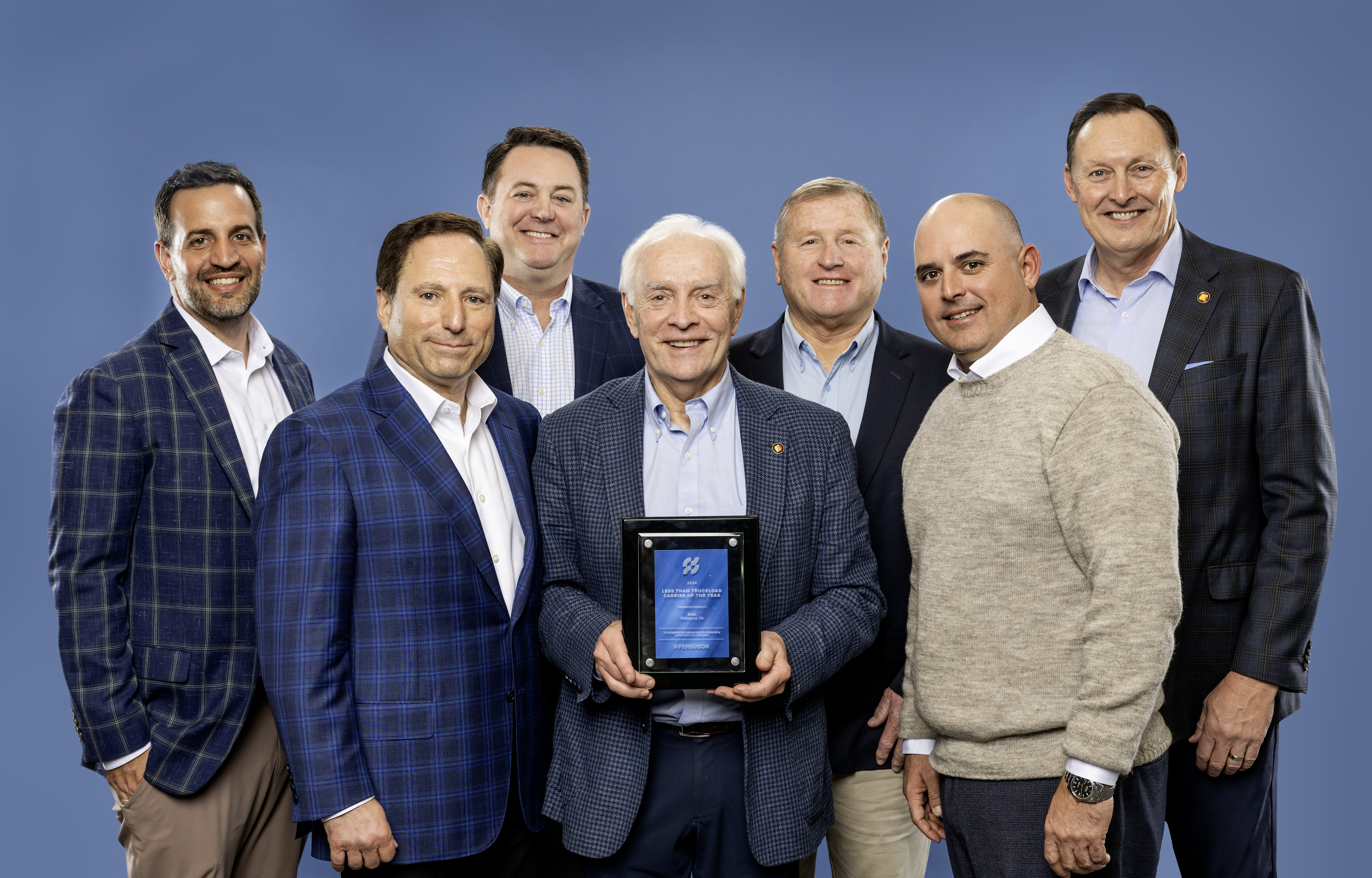 Photo courtesy of Ferguson : Estes – (from left to right) –  Front Row : Michael Jacobs, SVP of Supply Chain Ferguson; Rob Estes President and CEO Estes (holding the award); David Simons, VP of Global Logistics Ferguson.  Back Row : Nick Palmucci, Director of Domestic Transportation Ferguson; Mike Gebhard, Director of Corporate Accounts; Rick Owens, Senior Corporate Account Executive; Mark Watson, VP of Corporate Accounts.