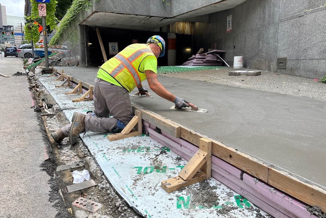 New exposed aggregate concrete sidewalk recently poured at Sixth Avenue and Smithfield Street adjacent to Mellon Square Garage