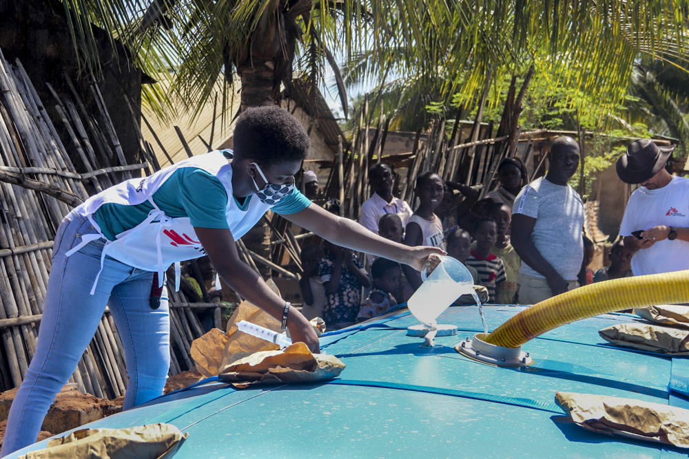 MSF staff member managing water treatment at a distribution site in the Natiti neighborhood of Pemba. Photographer: MSF