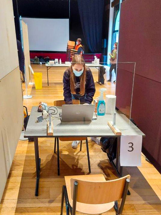 Een student geneeskunde van de KU Leuven bereidt het mobiele teststation voor in een basisschool. / © UZ Leuven