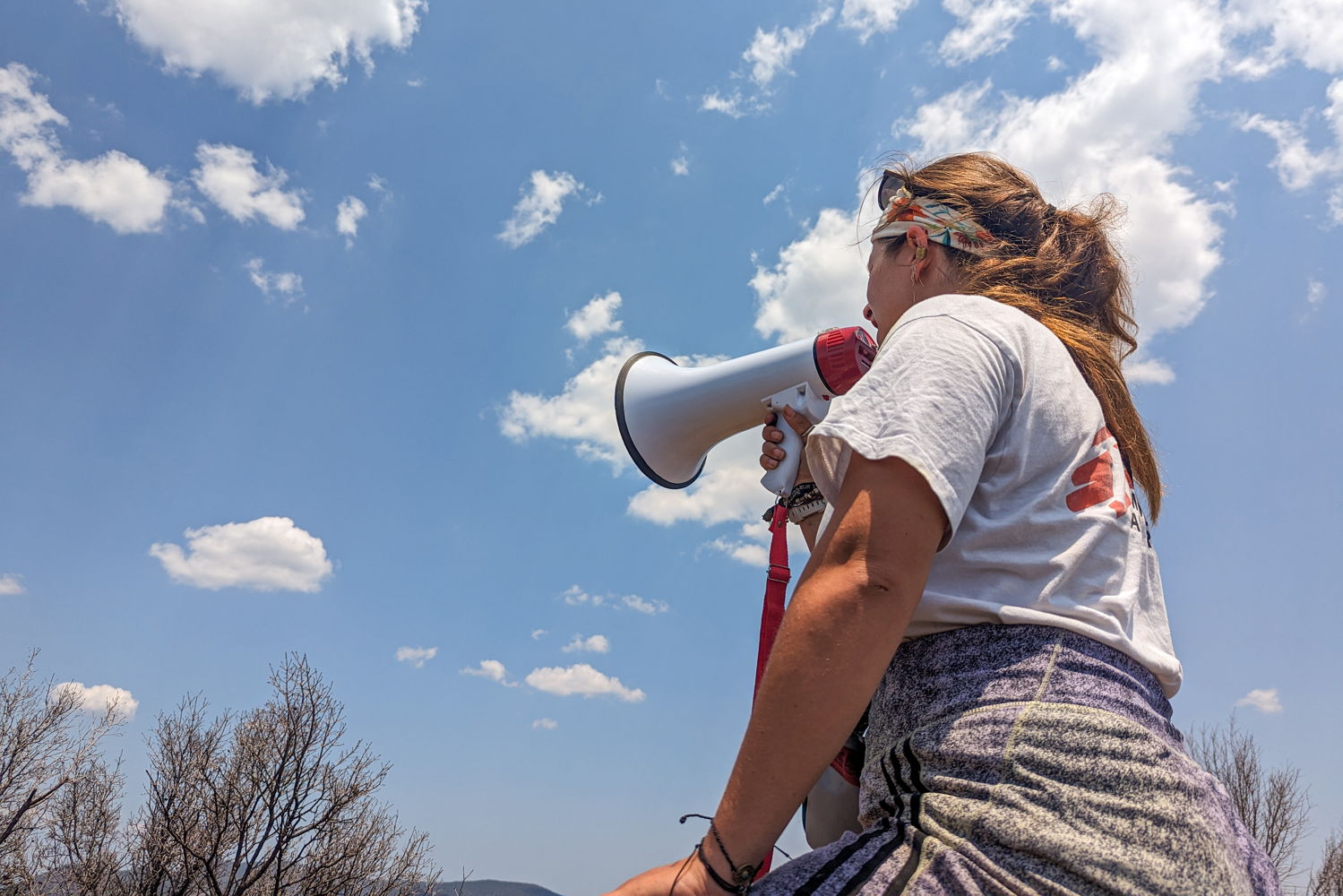 Title: Emergency medical aid activity in Lesvos, Greece Copyright: MSF/Evgenia Chorou Countries: Greece Date taken / Date Recorded: 11 July, 2023 Caption / Description: An MSF Lesvos team member shouts through a megaphone in order to locate people who are in need of urgent medical assistance. Since June 2022, MSF teams on Lesvos provide emergency medical care (EMA) to people who arrive on the island by boat. Our support consists of medical and psychological first aid, including referrals to hospital by ambulance. In July 2023, MSF assisted 1,031 people through the emergency medical aid activity, out of whom 26% were children.