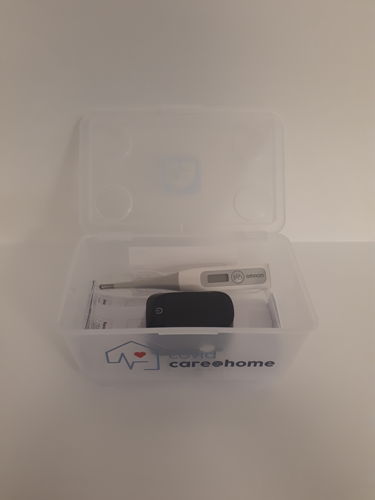 De box van CovidCare@home met een saturatiemeter en thermometer.