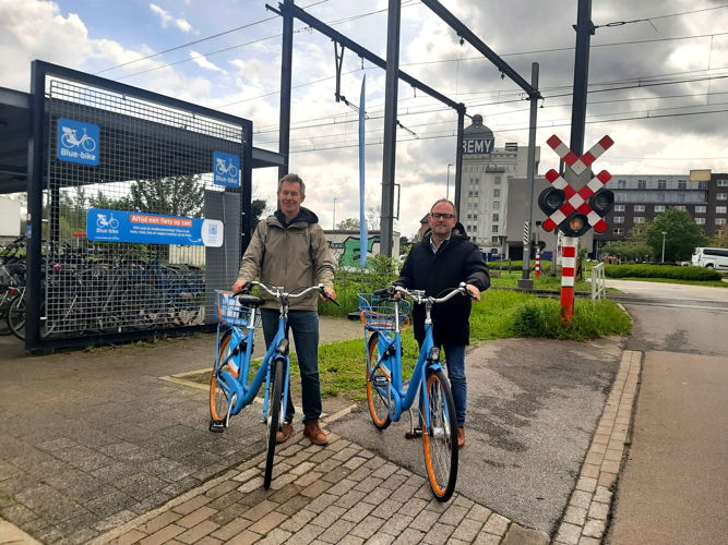 Stefaan Butaye  (algemeen directeur Bleu-mobility) en schepen David Dessers aan de nieuwe uitleenlocatie voor Blue-bikes aan het station van Wijgmaal