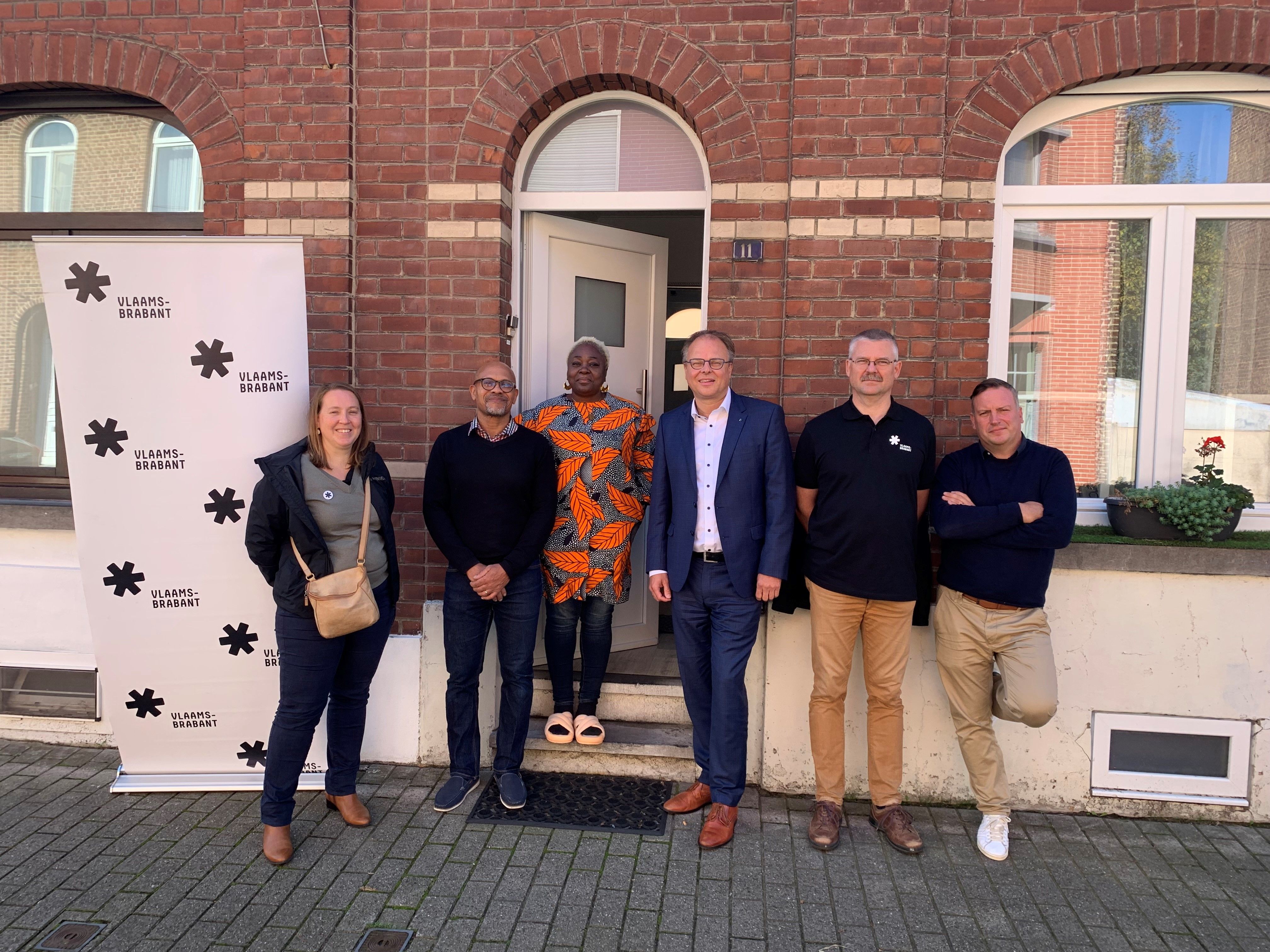 Gedeputeerde Gunther Coppens, burgemeester Jan Desmeth en vertegenwoordigers van de provincie brengen een bezoek aan een woning die vernieuwd werd in het kader van 'Ruisbroek Renoveert'