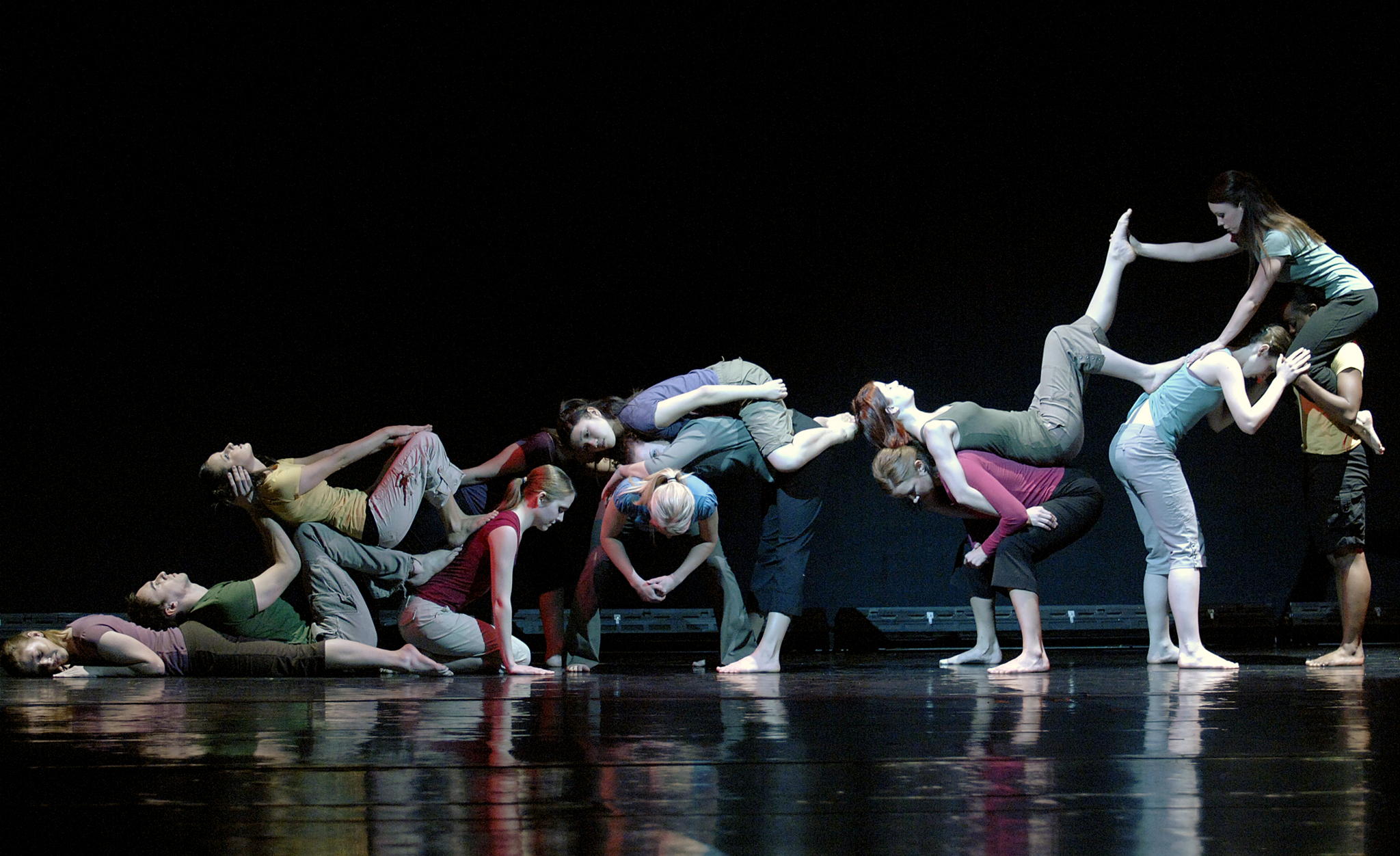UCO dance students from the Kaleidoscope Dance Company perform a contemporary piece, creating an interconnected human sculpture on stage.