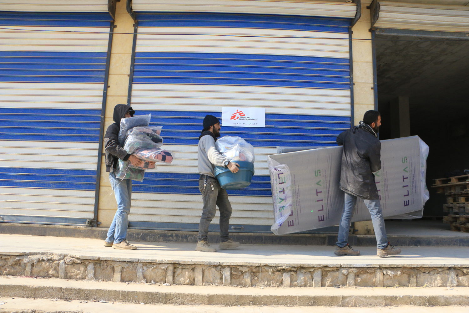 Title: MSF response to the earthquakes through Atmeh Hospital Copyright: Abdul Majeed Al Qareh Countries: Syria Date taken / Date Recorded: 11 February, 2023 Caption / Description: MSF team members load trucks with necessities for distribution to earthquake victims. February 11, 2023.