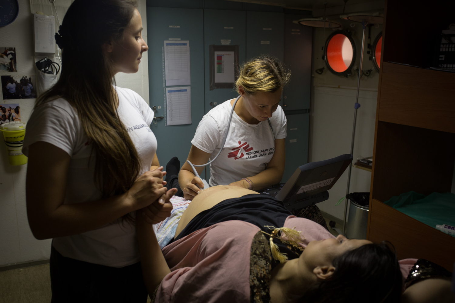 A 23-weeks pregnant woman receives a checkup from MSF midwife Nina Egger, while MSF Humanitarian Affairs Officer, Seraina Eldada translates in Arabic. September 2018. Copyright: Maud Veith/SOS MEDITERRANEE