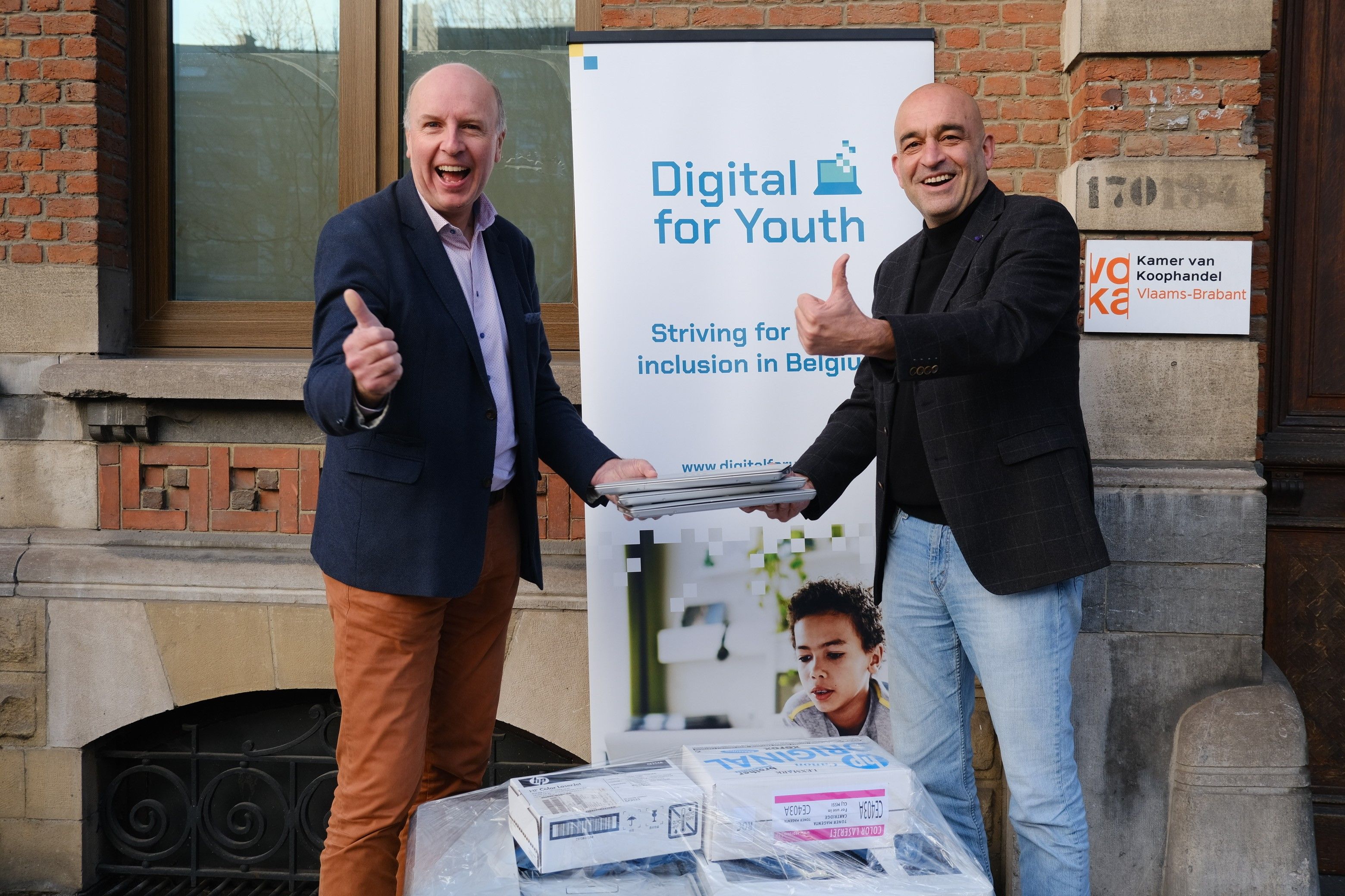 Hans De Backer, general manager Digital for Youth neemt de laptops van Voka-KvK Vlaams-Brabant in ontvangst