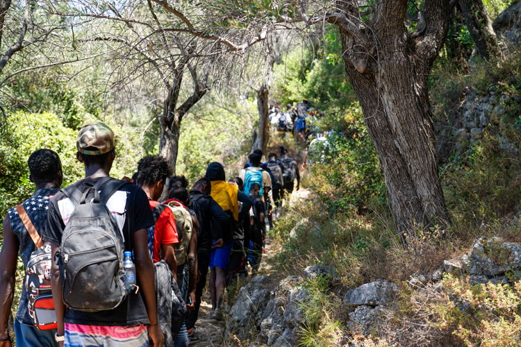 Medium shot of newly arrived people walking down a rocky path in Samos island, Greece. MSF’s emergency medical aid response has shown the high medical and humanitarian needs amongst new arrivals. During our interventions, most people we assist are exhausted and severely distressed. A lot of them are dehydrated after spending a long time, sometimes several days, in the bush without access to food and... Copyright MSF/Alice Gotheron
