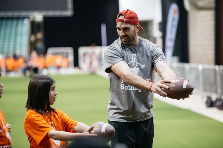 Brad Sinopoli with a participant in the JumpStart Games. Photo credit: CFL.ca/Reid Valmestad