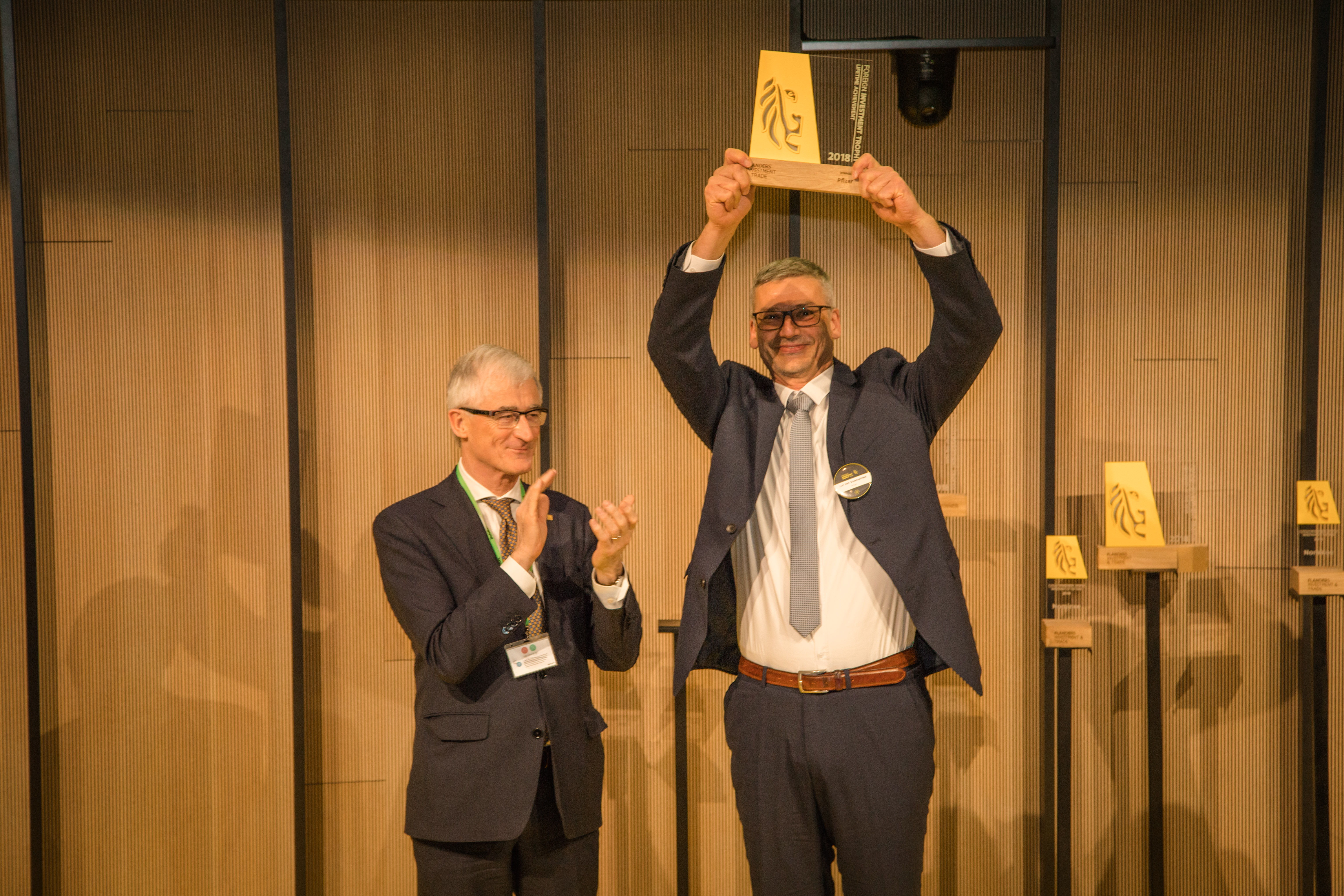 Vlaams Minister-President Geert Bourgeois (l.) overhandigde de Lifetime Achievement Trophy voor Pfizer aan Luc Van Steenwinkel (r.), Site Leader van de productie- en verpakkingssite van Pfizer in Puurs.