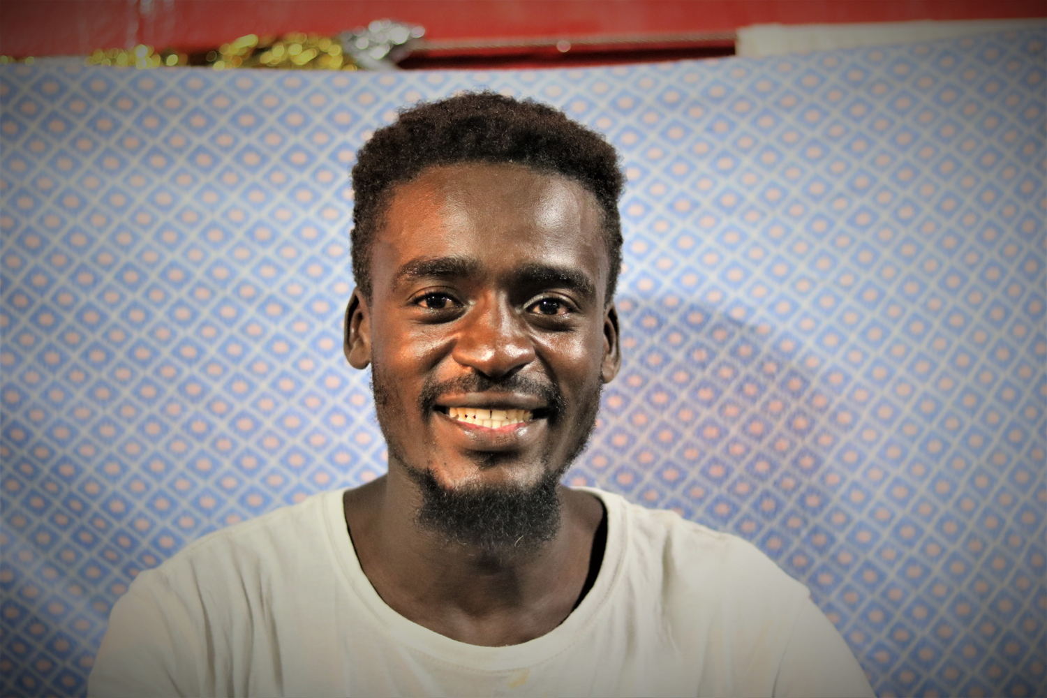 Abdulmoniem, 24 years old, Sudan.

Abdul doesn’t know how to swim. He thought they would be given life jackets, but they weren't. He says they left at night, after midnight, but he doesn’t remember the crossing itself very well: “We were seasick. Everything in our mind was circling. We knew there were only two options: to arrive or to die. Some people started to cry. But even talking is forbidden on the small ship. Even a small movement can flip us into the sea. So we tried to be very quiet. We knew the risk, but it’s better to die, than to live in Libya. If you are asking why we tried to cross, maybe you don’t know Libya well.” 

Abdul used to be a Barber in Darfur. He left around 1.5 years ago fearing for his life due to the situation there. His journey to Libya began with a 16 day journey through the desert, via Chad. Arriving in Libya, they came to a “police station” or army checkpoint, “but it was not like a police station we know. Without any kind of reason, they started to beat us. They told us, ‘you know Libya, there is a war. There is suffering. But still you come.” Then they took their passports, and held them until they were able to contact friends at home in order to send money to continue their journey. “They consider us as animals. A black man in Libya is like an animal.” In the beginning, he had planned to stay in Libya, but it became too difficult. He would be randomly stopped in the street and put in jail. 

Abdul tried to cross the Central Mediterranean Sea three times. The first time he was arrested on shore. The second time the engine broke and they had to turn back. In the beginning, he had planned to stay in Libya, but it became too difficult. They would be arbitrarily detained. He described how him and his friends would be randomly stopped in the street and put in jail.
Copyright: Hannah Wallace Bowman/MSF