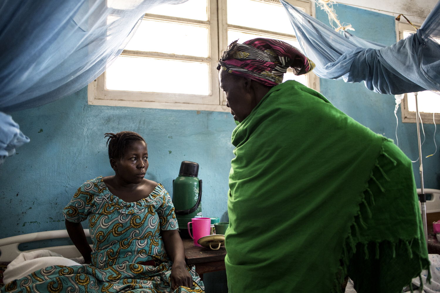 Denise Borive (31) (R), speaks with her mother as she recovers from an emergency caesarian in a hospital room on 2 March 2018 in Bunia. After hearing about a pending attack on her village she fled on foot with her mother and children at nine months pregnant to seek safety. ©John Wessels/MSF