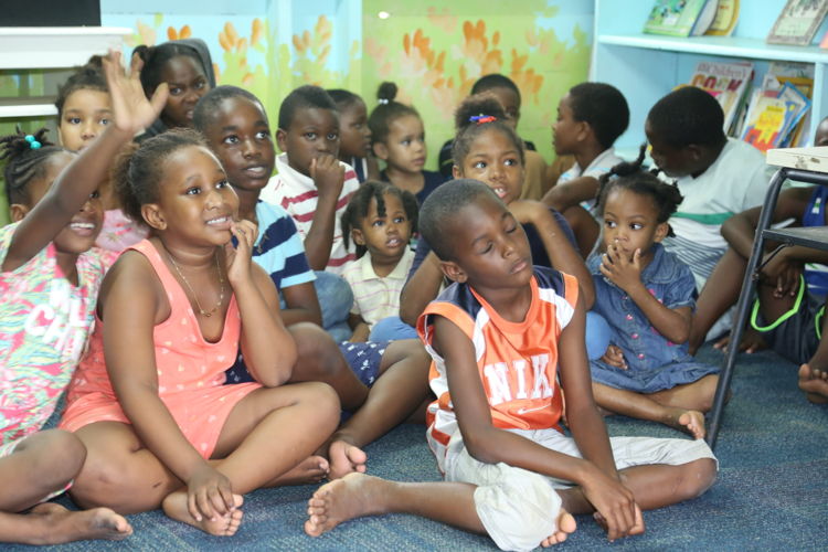 Students gather in the school's library for the hand over of the school bags.