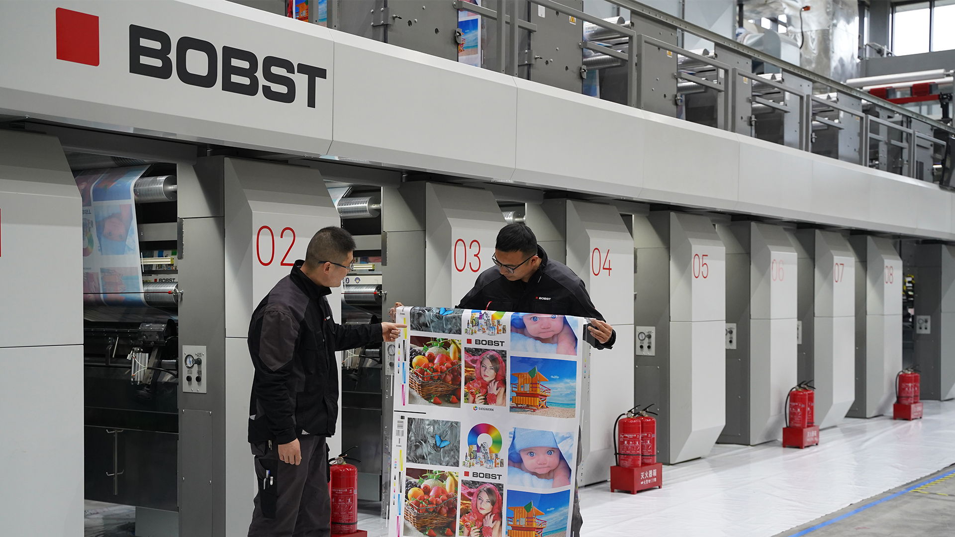 Messrs Shuhui Sun (right) and Bo Zhang (left), process engineers at Bobst Changzhou, examining the technical print sample printed with Siegwerk water-based inks in Bobst (Changzhou) Competence Center.