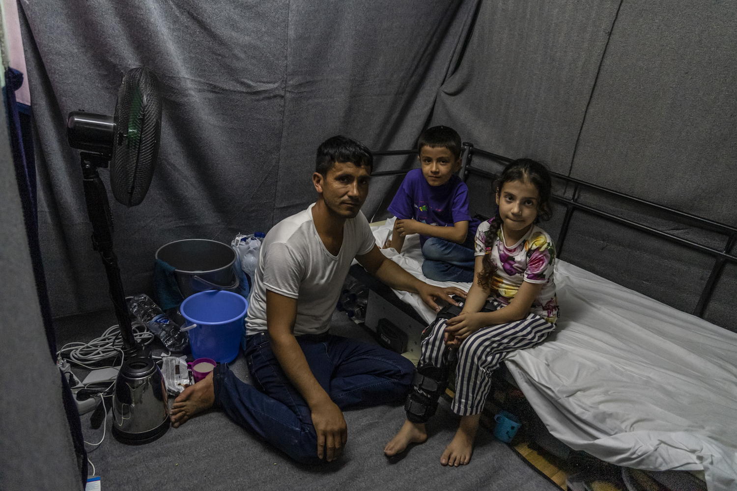 Fatima, a 9-year-old from Afghanistan, is seen by an MSF doctor in a paediatric clinic outside Moria camp on Lesbos. In 2015 a bomb exploded on the street where her house was. Her 4-year -old brother died and Fatima, who was outside at the time of the explosion, was thrown by the blast. Since then she has had three surgeries in Afghanistan but her family decided to leave the country in order to look for better treatment for her. Fatima's family of six live in a four metre sqaure space in a part of a container in Moria. Taken 14 August 2019, credit Anna Pantelia/MSF