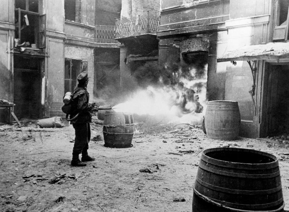 AKG867139 House-to-house-fighting: The entrance to a cellar is set alight by a flame thrower.– Photo, August 1944. ©akg-images / Ullstein Bild