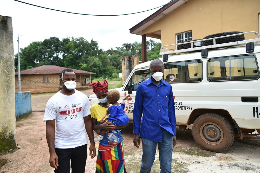 Yandeh Sillah and her daughter, Kaday Kamara (1 year old), walking together with the Ministry of Health and Sanitation laboratory assistant (right), and MSF clinical officer, Joseph Sesay, at the Kagbere tuberculosis Direct Observation Therapy (DOT) site in Bombali District, Sierra Leone. Kaday was diagnosed with drug sensitive tuberculosis (TB) and is receiving treatment at the MSF supported Kagbere DOT site.Yandeh walks 2 hours from her village to get to the Kagbere tuberculosis Direct Observation Therapy | Date taken: 20/07/2023 | Photographer: Mohamed Saidu Bah | Location: Sierra Leone