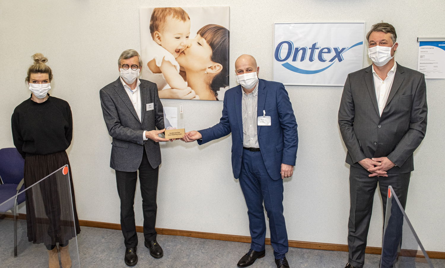 Gedeputeerde Kurt Moens overhandigt de trofee aan de vertegenwoordigers van Ontex.