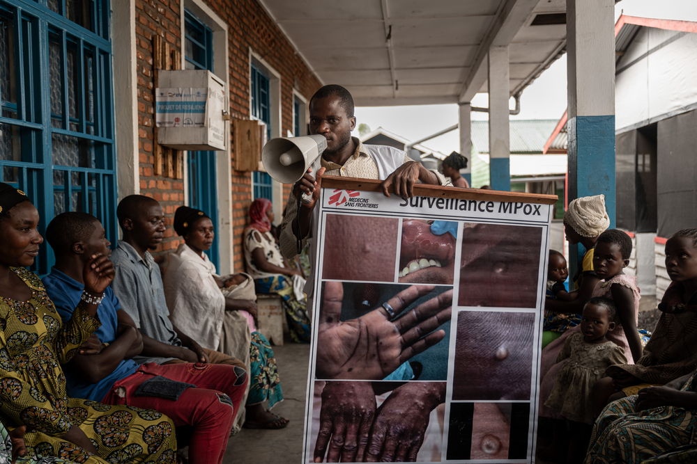 An MSF health promoter explains the signs and symptoms of mpox to camp people present inside the health centre supported by MSF in the Kanyaruchinya displacement site, on the outskirts of Goma. Date taken: 28/08/2024 | Photographer: Michel Lunanga | Location: North Kivu