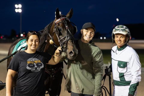 Travis Forbes and Katie Miller pose with Livin Ona Dream and driver J. Bradley Harris in the winner's circle on June 20, 2022 at Grand River Raceway