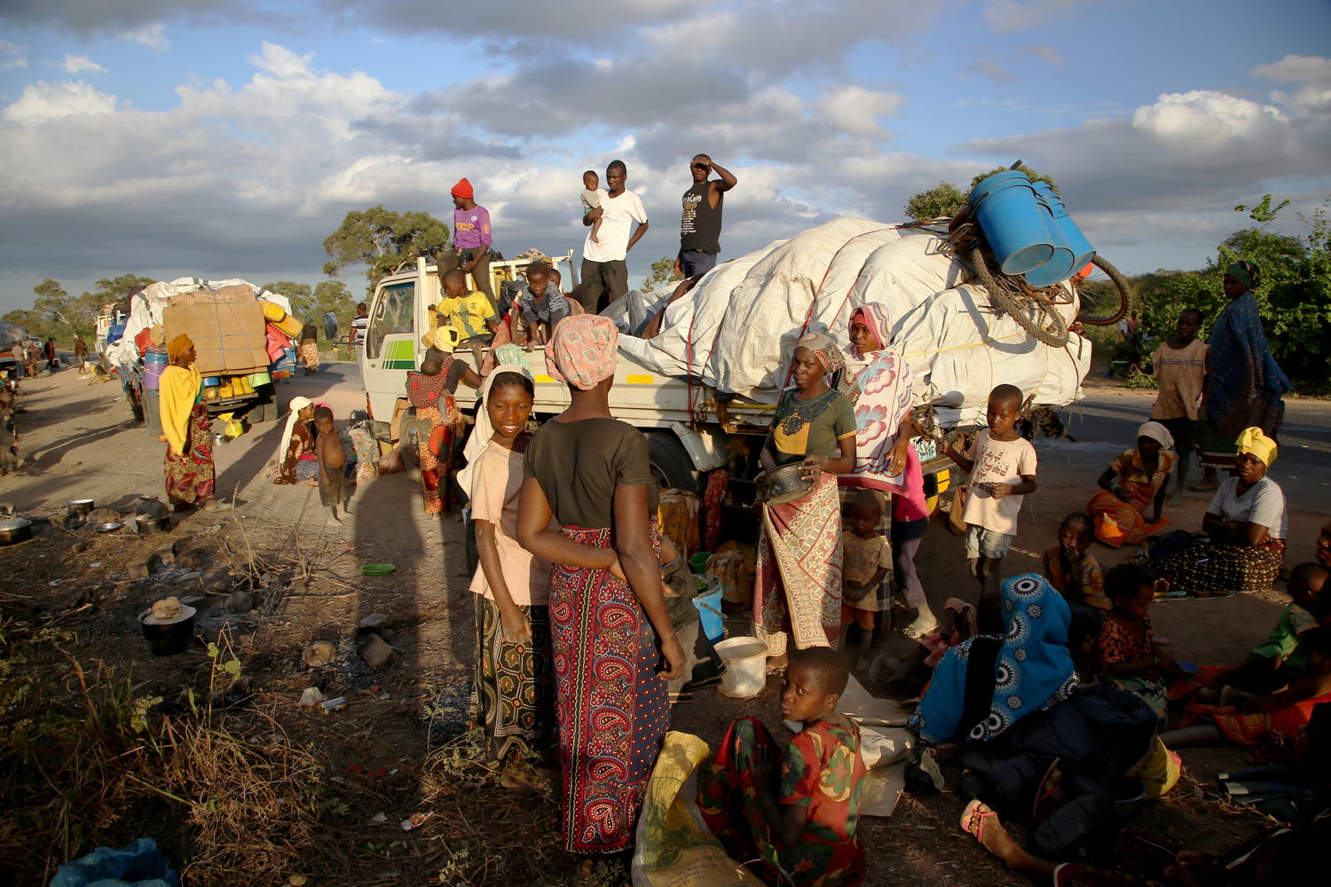 People displaced by the conflict in Cabo Delgado, a northern province in Mozambique, wait next to a truck on the outskirts of Mueda.