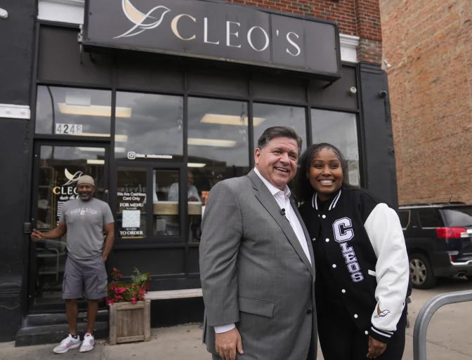 Gov. Pritzker stands with Kristen “Chef Krissy” Ashley Harper, owner and chef of Cleo’s in the Bronzeville neighborhood of Chicago. (Erin Hooley/AP)