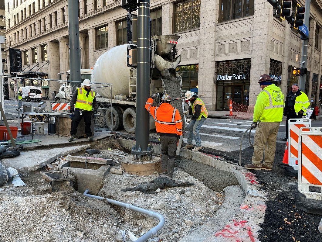 Crews pouring concrete to support the new curb at Sixth Avenue and Smithfield Street